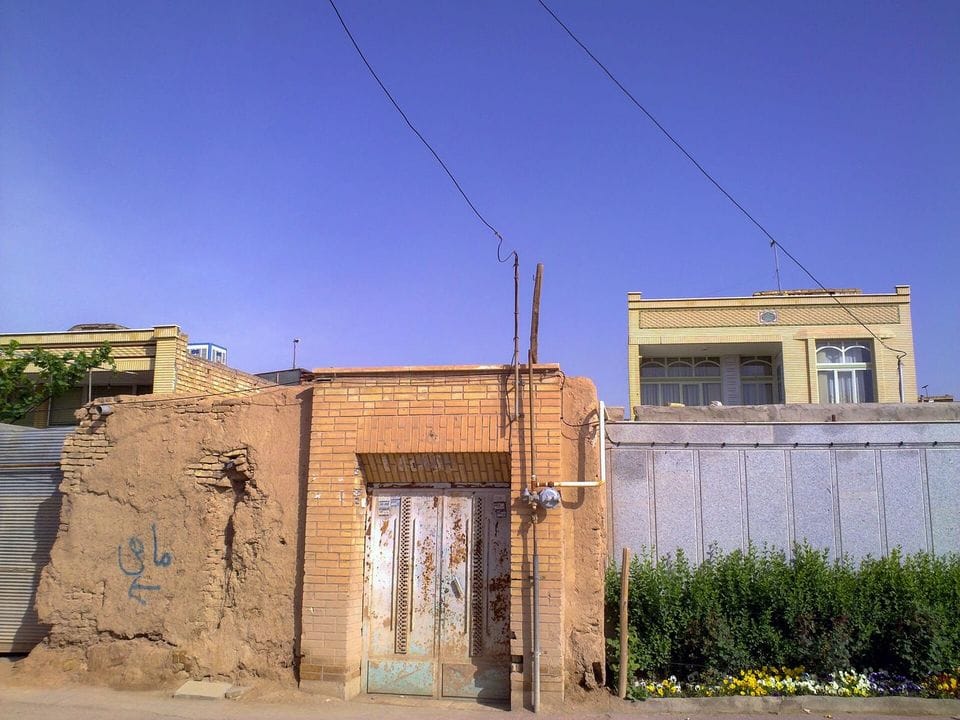 Low sand-coloured houses along a quiet lane
