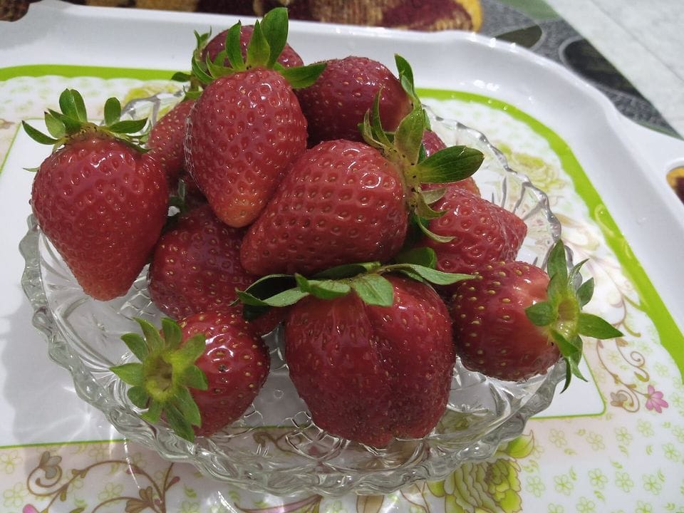 Strawberries heaped in a glass bowl