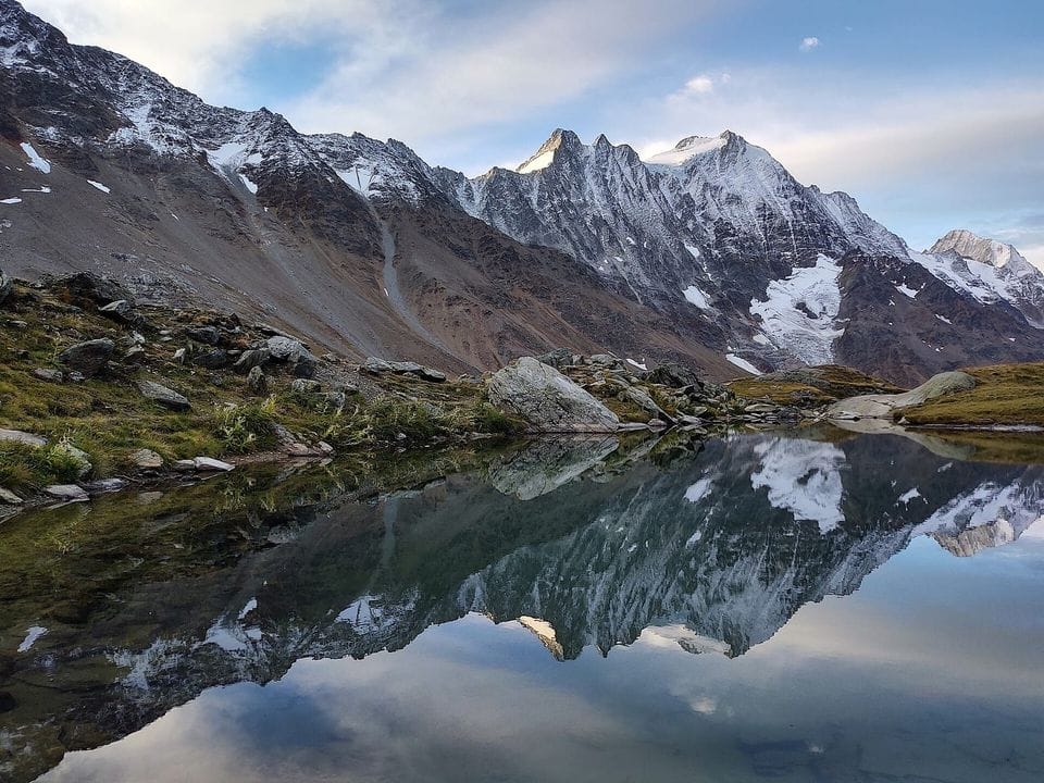 Snow-dusted mountain ridge reflected in a still lake