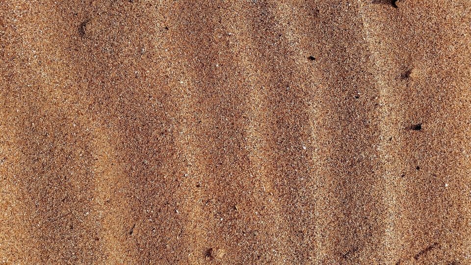 Fine ripples in brown beach sand